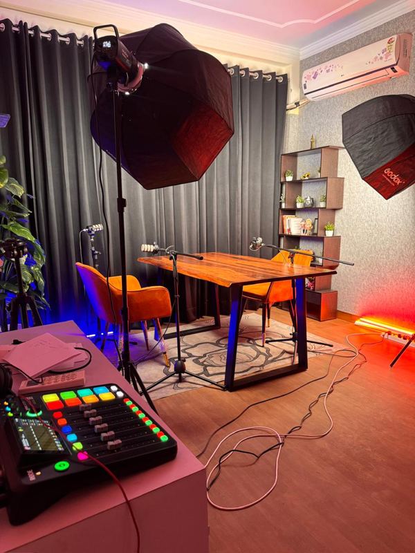 Grey textured wall video shoot setup with live-edge wooden table at Spettro Studios, West Delhi